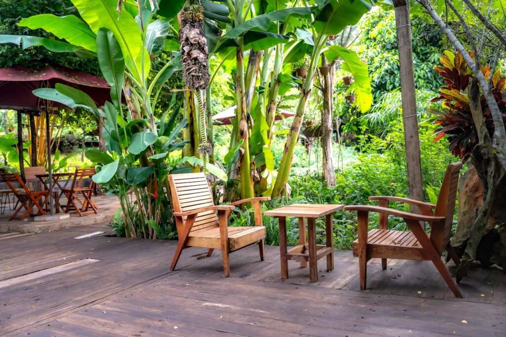 Mastering the First Impression: Your intriguing post title goes here Wooden chairs and table in a lush tropical garden setting.